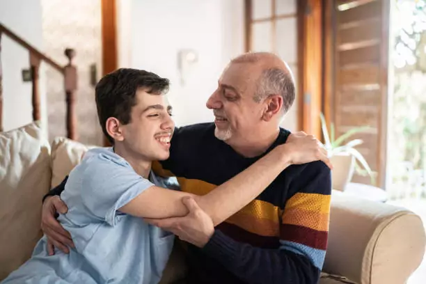 young man being supported by older male