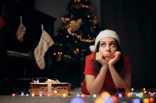 Sad Stressed Woman Thinking under the Christmas Tree