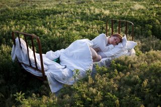 bed in a green field